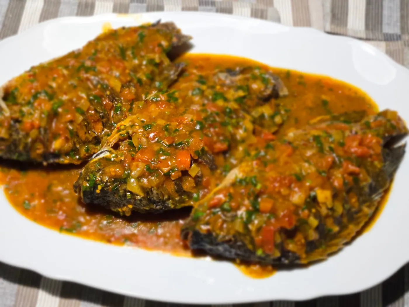 Tilapia Wet Fry: Fried tilapia simmered in a rich tomato, onion and dhania sauce.